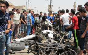 People gather at the site of an explosion in Uraiba marketplace, Sadr City, Baghdad.