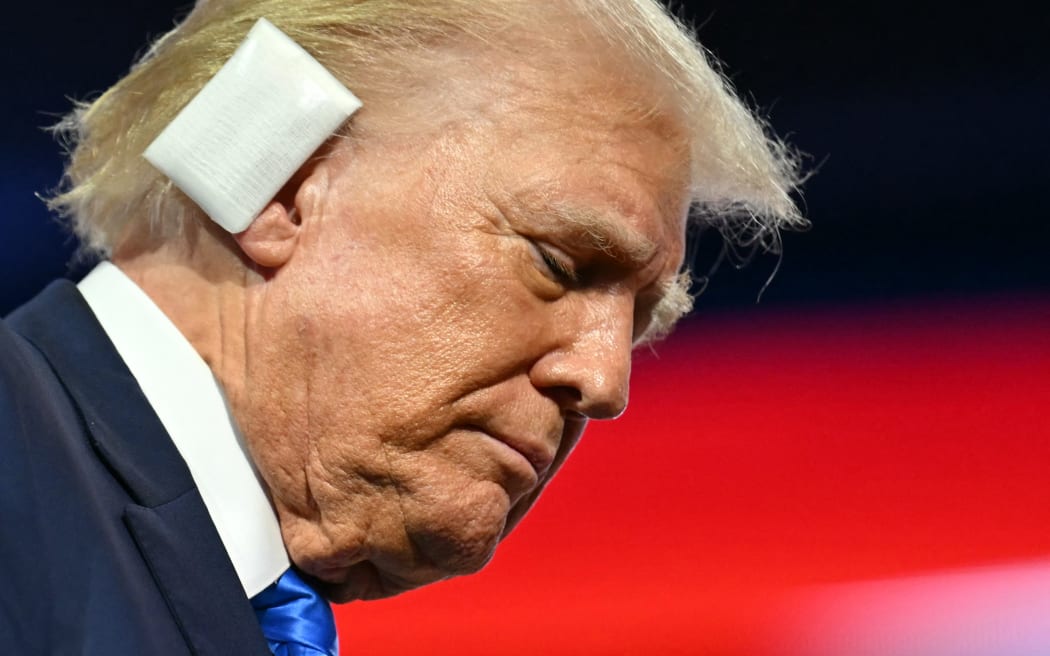US former President and 2024 Republican presidential candidate Donald Trump, a bandage on his ear after being wounded in an assassination attempt, departs at the conclusion of the second day of the 2024 Republican National Convention at the Fiserv Forum in Milwaukee, Wisconsin, July 16, 2024. Days after he survived an assassination attempt Donald Trump won formal nomination as the Republican presidential candidate and picked right-wing loyalist J.D. Vance for running mate, kicking off a triumphalist party convention in the wake of last weekend's failed assassination attempt. (Photo by ANGELA WEISS / AFP)