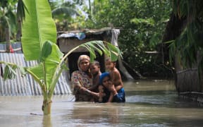 Bangladeshi flood victims look for relief materials in Kurigram, northern Bangladesh on 16 August.