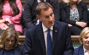 A video grab from footage broadcast by the UK Parliament's Parliamentary Recording Unit (PRU) shows Britain's Chancellor of the Exchequer Jeremy Hunt announcing tax and spending measures, part of medium-term fiscal plan to MPs at the House of Commons, in London, on October 17, 2022.