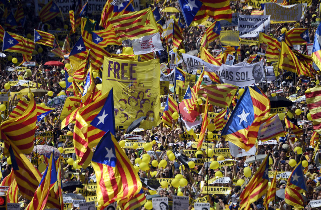 People wave Catalan pro-independence 'estelada' flags during a demonstration to support Catalan pro-independence jailed leaders and politicians and called by 'Espai Democracia i Convivencia' platform that groups separatist collectives and unions in Barcelona on April 15, 2018.