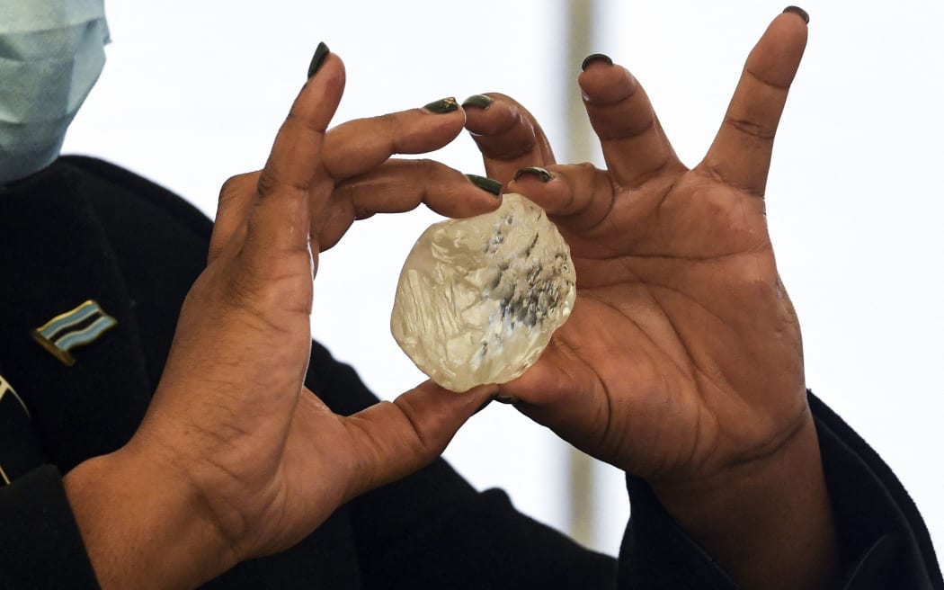 A Botswana member of cabinet holds a gem diamond in Gaborone, Botswana, on June 16, 2021. - A 1,098-carat stone described as the third largest of its kind in the world.
The stone, found on June 1, 2021 was shown to President Mokgweetsi Masisi in the capital Gaborone.