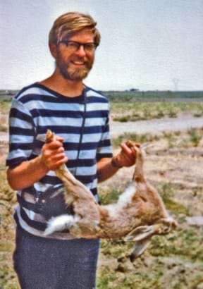 John Flux in Iran in 1977 with a road kill hare