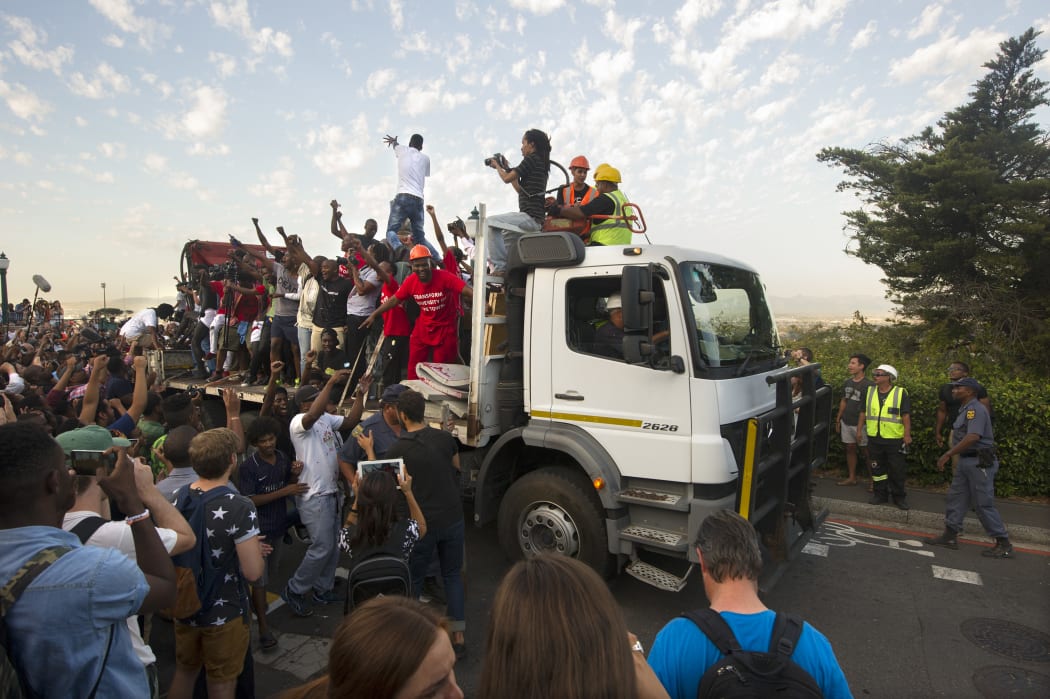 Students cheer as the statue is removed