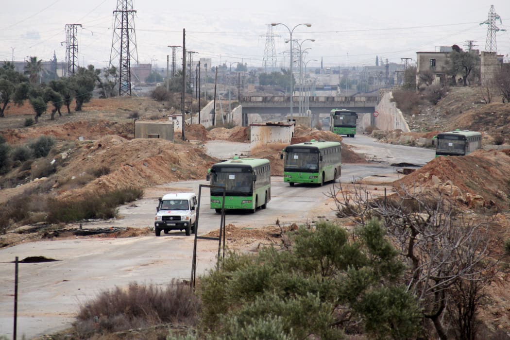 Buses sent to evacuate residents from Fuaa and Kafraya villages arrive at a rebel-held checkpoint on the outskirts of the two Syrian villages under rebel siege, on December 18, 2016.
