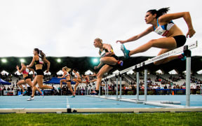 Competitors jump in the Women 100 Metre Hurdles