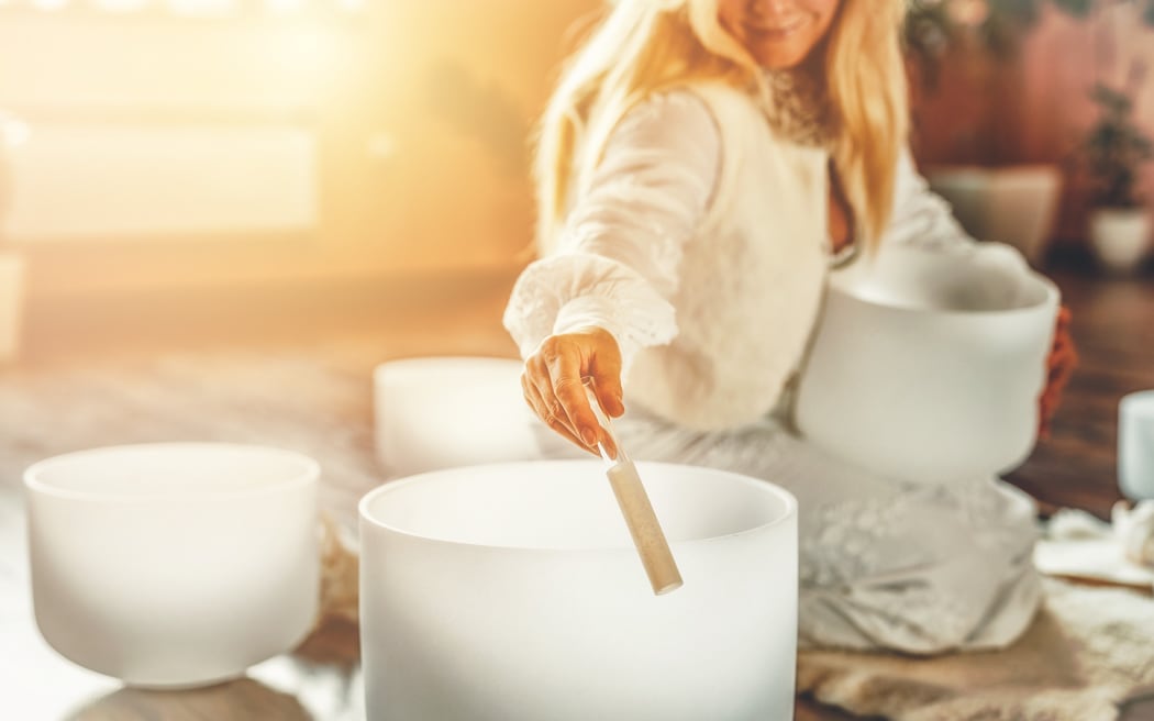 Woman playing on a crystal bowl.