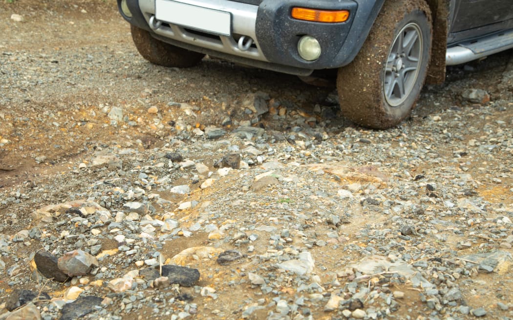 Car wheel in dirty ground road.