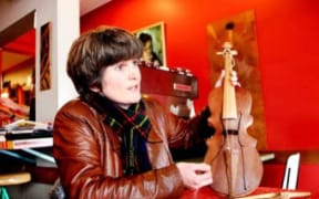 Megan Collins holding a rabab, used in West Sumatra to accompany migration stories