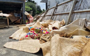 Vasiti Pele and her husband Siosaia's sodden belongings piled outside their West Auckland home after their house flooded.