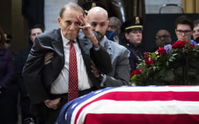 Former US Senator Bob Dole stands up and salutes the casket of the late former President George H.W. Bush as he lies in state at the U.S. Capitol, December 4, 2018 in Washington, DC