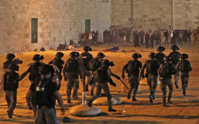 Israeli security forces advance amid clashes with Palestinian protesters at the al-Aqsa mosque compound in Jerusalem,