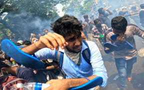 Sri Lankan anti-government protesters run away from tear gas during a protest that resulted in protesters occupying the prime minister's office at Colombo, Sri Lanka. 13 July 2022 (Photo by Tharaka Basnayaka/NurPhoto) (Photo by Tharaka Basnayaka / NurPhoto / NurPhoto via AFP)