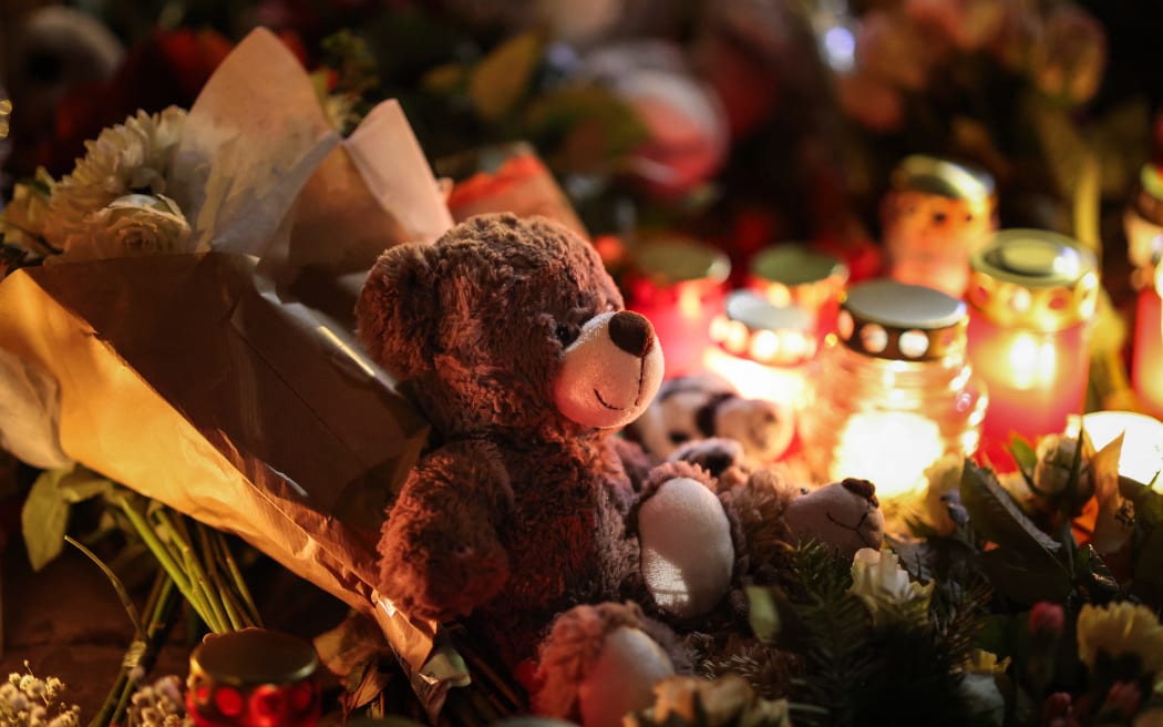 A teddy bear lies at a makeshift memorial near the site of a car-ramming attack on a Christmas market in Magdeburg, eastern Germany, on December 21, 2024. - The death toll in the attack on December 20, rose to 5 on December 21, 2024, with over 200 injured, according to the head of the regional government, Reiner Haseloff. (Photo by Ronny HARTMANN / AFP)