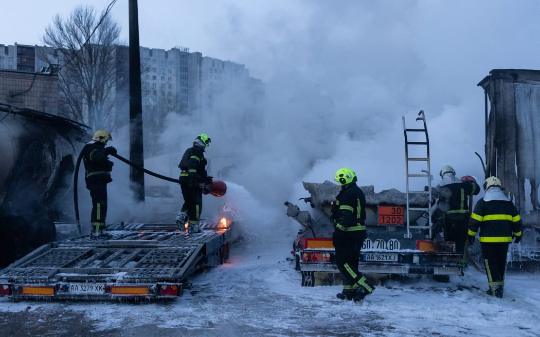 Ukrainian emmergency personnel work to extinguish a fire at the site of an air attack in Kyiv on January 24, 2026, amid the Russian invasion of Ukraine. Russian strikes killed one person and injured 23 others in Ukraine's capital and the northeastern city of Kharkiv overnight, authorities said early on January 24, 2026. The country was under an air raid alert with military authorities in Kyiv warning of drones and ballistic missiles. (Photo by Oleksandr Magula / AFP)