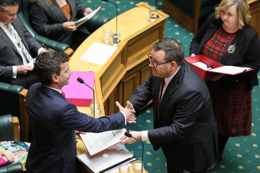 Grant Robertson gives a copy of the budget speech to David Seymour