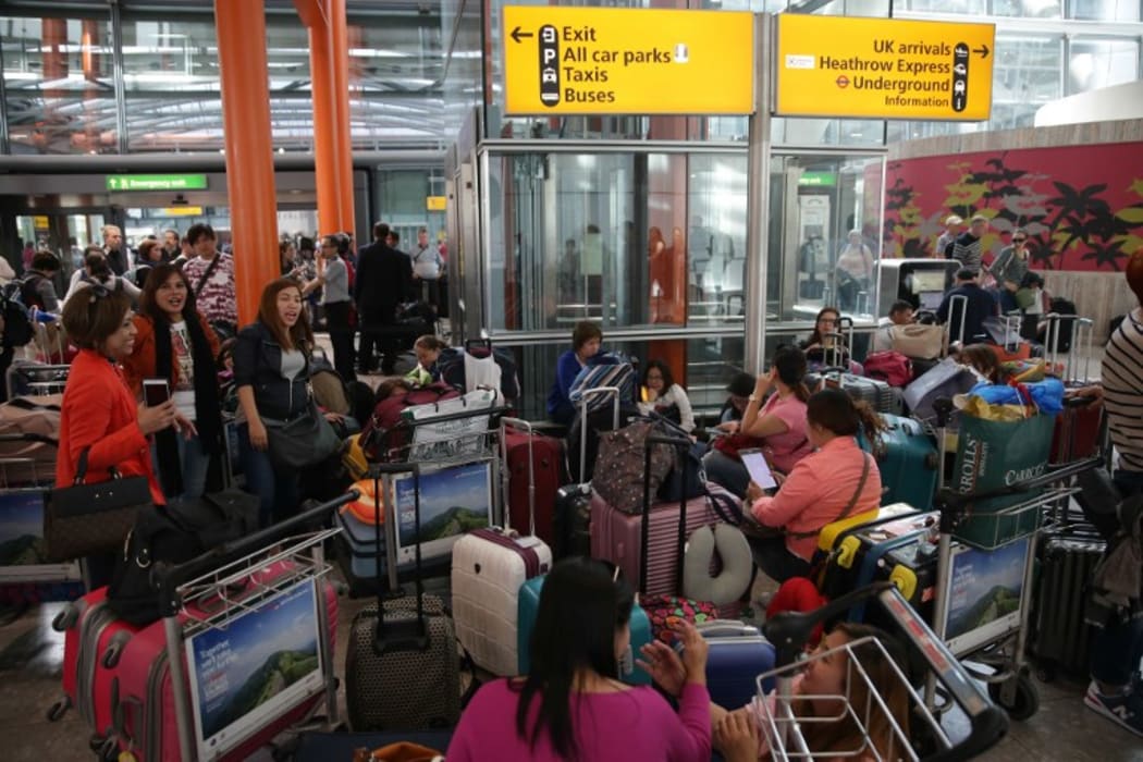 Travellers wait stranded at Heathrow Airport Terminal 5 after British Airways flights where cancelled at Heathrow Airport.