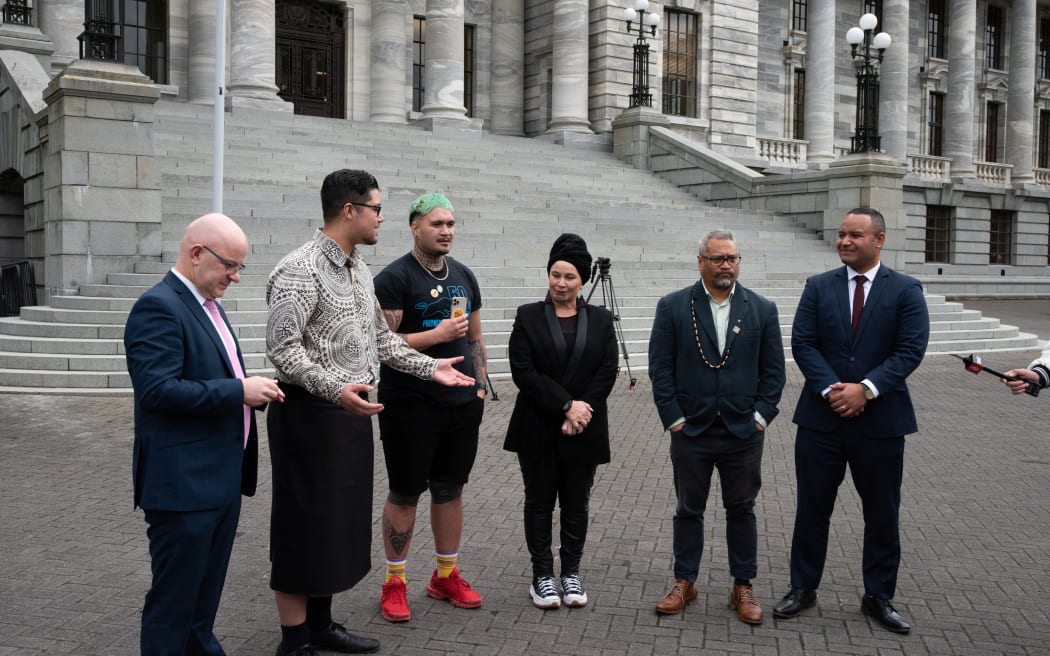 MPs join the authors of the Dawn Raids petition in front of Parliament.