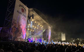 L.A.B performing on stage at night under pink and purple lighting.