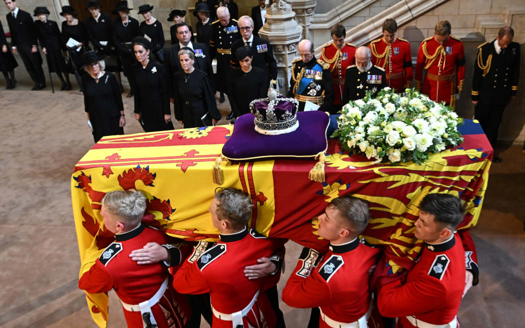 Pallbearers from The Queen's Company, 1st Battalion Grenadier Guards carry the coffin of Queen Elizabeth II past Camilla, Queen Consort, Catherine, Princess of Wales, Sophie, Countess of Wessex, Meghan, Duchess of Sussex, Prince Edward, Duke of Kent and Prince Richard, Duke of Gloucester, as they arrive at Westminster Hall at the Palace of Westminster in London on 14 September, 2022, where the coffin will to Lie in State.