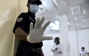 Police and medical staff at an Ivory Coast airport waiting for passengers flying in from Guinea.