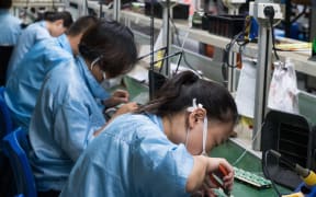 Chinese electronics factory workers in an industry manufacturing mssembly line