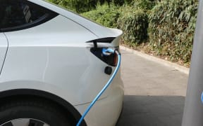 An electric car of the company Tesla is charged at a charging station on a parking lot in Cologne, Germany.