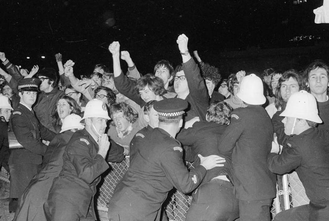 Anti-apartheid demonstrators are held back by police in 1970