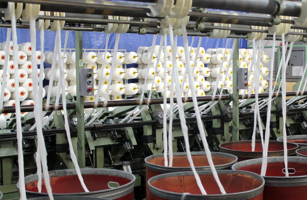 Wool being delicately put into metal vats ready to be spun later on.