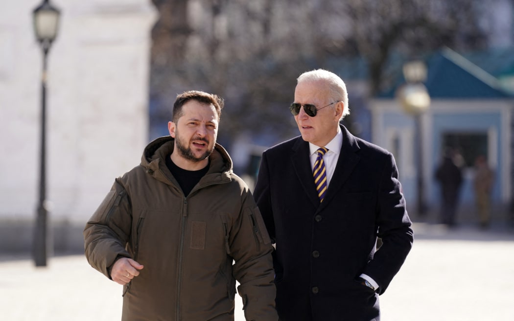 US President Joe Biden (R) walks next to Ukrainian President Volodymyr Zelensky (L) as he arrives for a visit in Kyiv on 20 February, 2023.,
