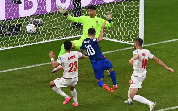 USA forward Christian Pulisic scores his team's first goal past Iran's goalkeeper Alireza Beiranvand during the Qatar 2022 World Cup Group B football match between Iran and USA at the Al-Thumama Stadium in Doha on 29 November, 2022.