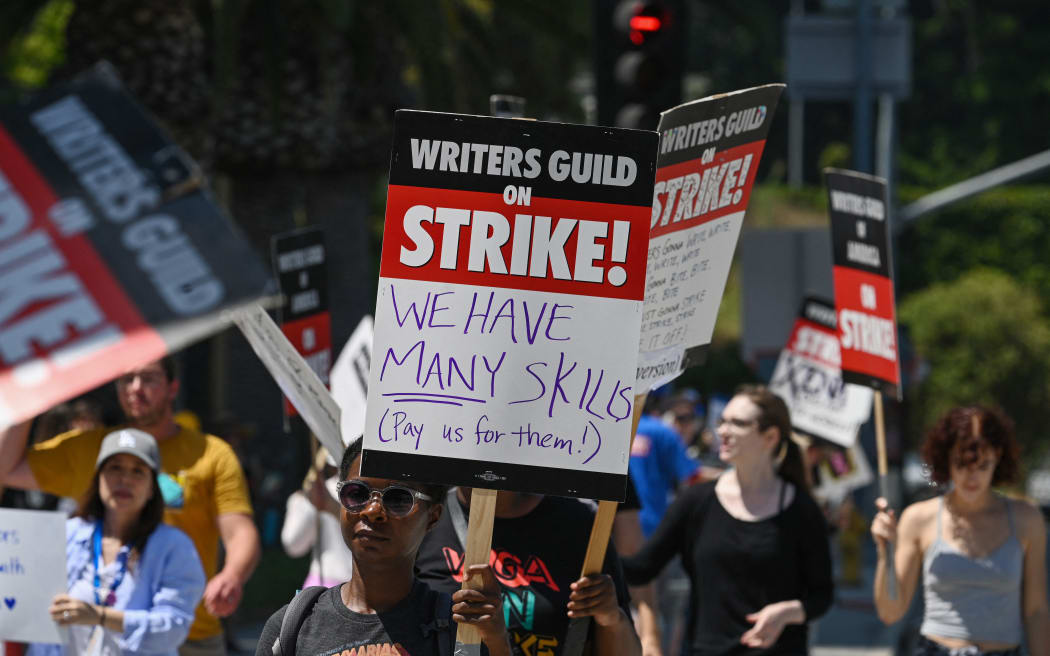 Hollywood writers and their supporters walk the picket line outside Universal Studios Hollywood in Los Angeles, California, June 30, 2023. Hollywood's summer of discontent could dramatically escalate this weekend, with actors ready to join writers in a massive "double strike" that would bring nearly all US film and television productions to a halt. The Screen Actors Guild (SAG-AFTRA) is locked in last-minute negotiations with the likes of Netflix and Disney, with the deadline fast approaching at midnight Friday (0700 GMT Saturday). (Photo by Robyn Beck / AFP)