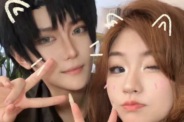 Lexie Chang (left) dressed up as Xiao Yi, the male protagonist in the mobile game Light and Night, stands near a woman with cat ears and sketches appearing on their faces in the image.