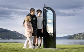 Kuini Parker, 6, Tama Parker (centre), 13, and Robin Luff, 13, read a tohu whenua (cultural marker) near the harbour teeth which teaches them about when different iwi arrived in the area.