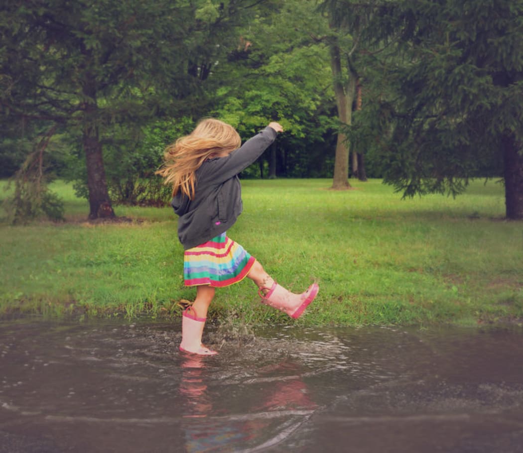 Child splashing in puddle