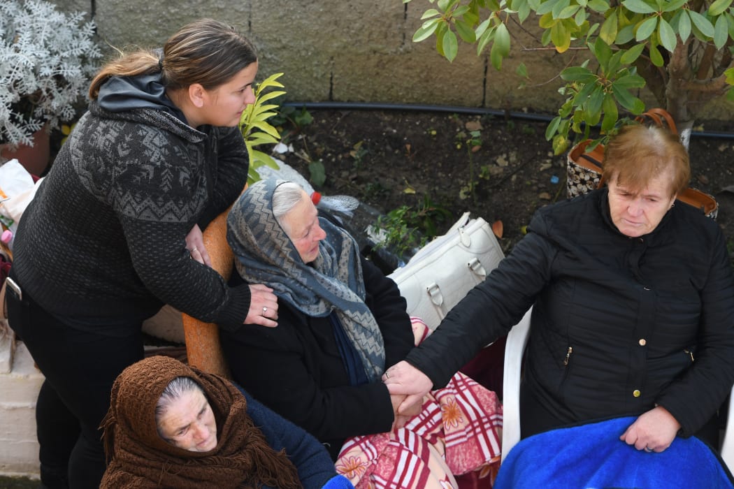 Relatives of people living in a collapsed building wait as Italian rescue search for bodies through the rubble.