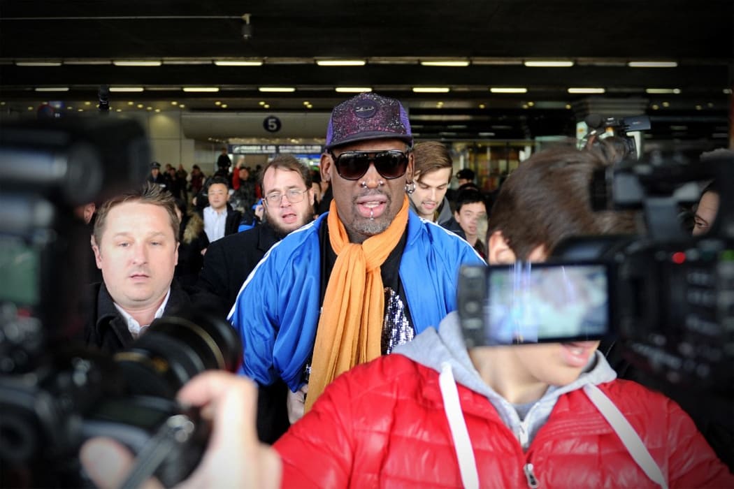 Canadian businessman Michael Spavor (L) walks with former US basketball player Dennis Rodman (C) after arriving from North Korea at Beijing International Airport on January 13, 2014.