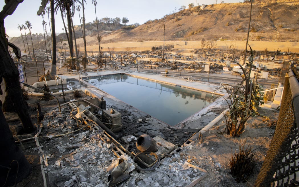 A swimming pool is surrounded by burnt remains of homes in Southern California on January 10, 2025. The California wildfires have collectively scorched nearly 38,000 acres, with Governor Gavin Newsom describing them as among the most severe in U.S. history, and damages projected to exceed $135 billion. (Photo by Sahab Zaribaf / Middle East Images via AFP)