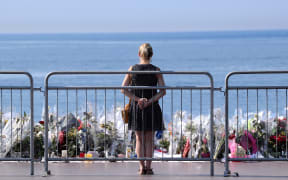 A woman stands by a make-shift memorial for the victims of the Nice truck attack.