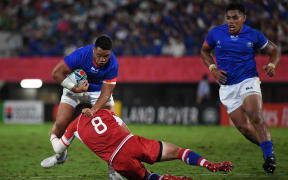 Samoan hooker Motu Matu'u is tackled by Russia's number eight Nikita Vavilin.