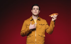 UK Comedian Ed Gamble holding a hotdog.