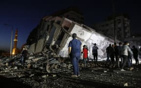 Palestinians gather in front of the rubble of the destroyed 13-storey Hanady Tower after Israeli airstrikes in Gaza City, on 11 May 2021.
