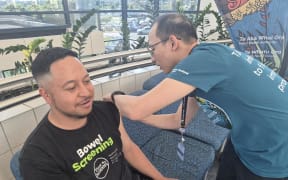 Kollin Hilihetule getting vaccinated at a pop-up clinic in Manukau