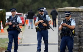 Armed police officers stand guard during the burial ceremony of the victims killed in Christchurch's mosque attacks at the Memorial Park Cemetery in Christchurch, New Zealand on March 21, 2019