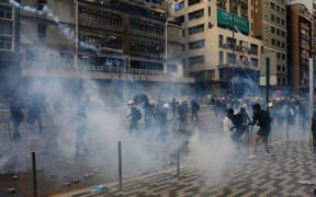 Riot police fire tear gas to disperse anti-government protesters in industrial district Kwun Tong, Hong Kong, on Saturday Aug 24, 2019.