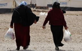 Syrian refugees leaving a World Food Programme market at a refugee camp in the Jordanian city of Mafraq.
