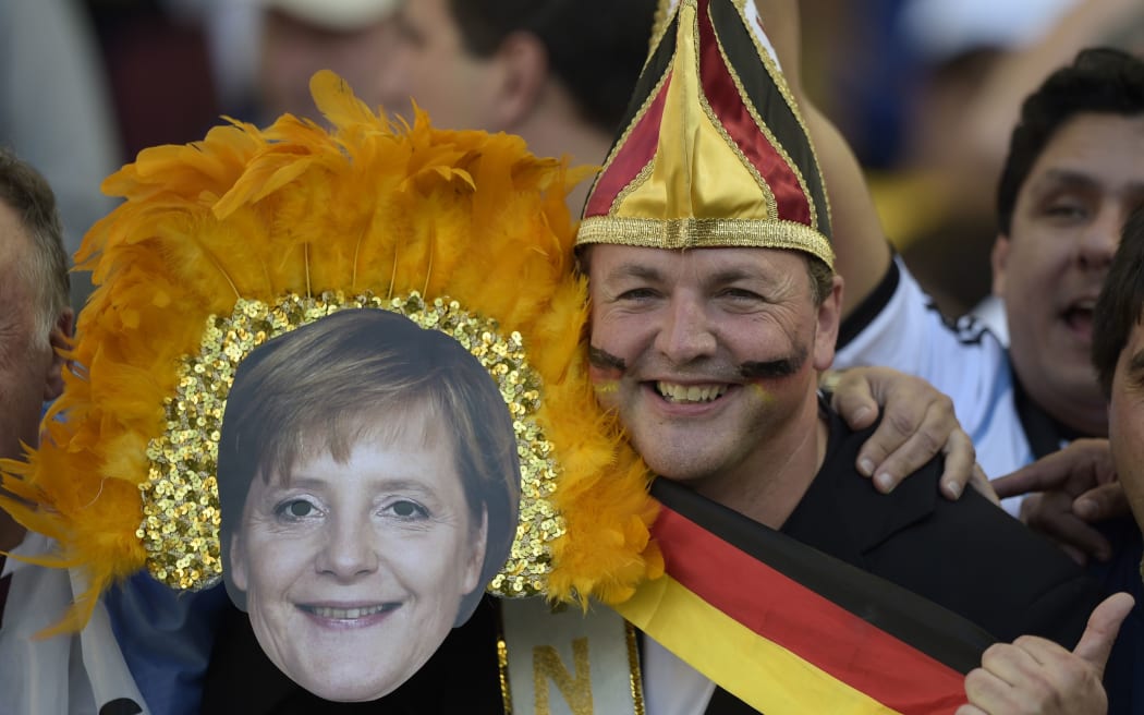 Germany fans, one wearing a mask of Chancellor Angela Merkel, at Maracana Stadium.