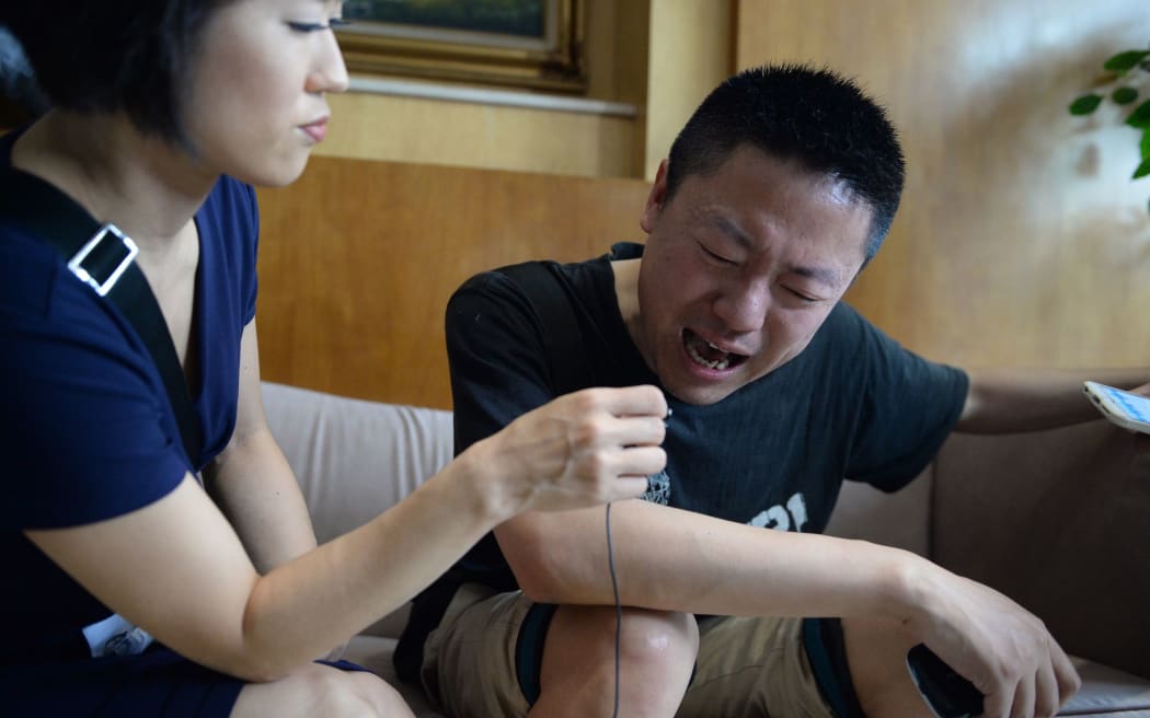 A relative of missing passengers who were on a ship which sank in the Yangtze River is interviewed by a journalist.