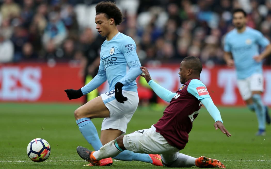 West Ham defender Patrice Evra tackles Manchester City's Leroy Sane.
