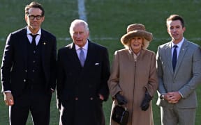 Britain's King Charles III and Britain's Camilla, Queen Consort pose for a photograph with Wrexham AFC Co-Chairman, US actor Ryan Reynolds and US actor Rob McElhenney during their visit to Wrexham Association Football Club in north Wales.